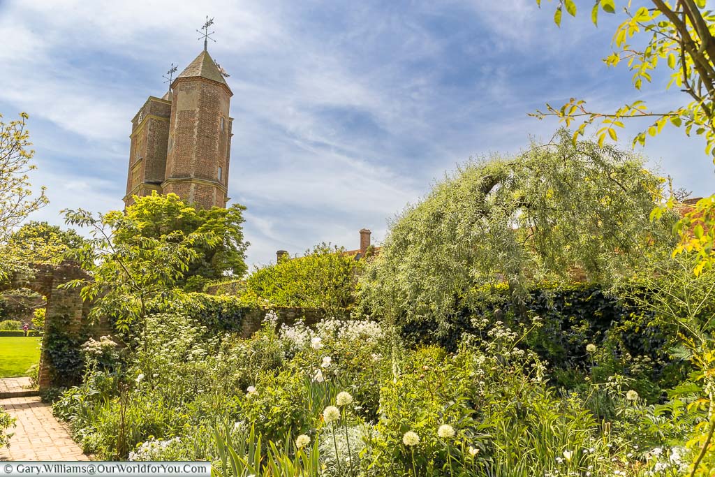 The mixed planing, all with pale flowers, in The White Garden with the tower of Sissinghurst Castle in the background