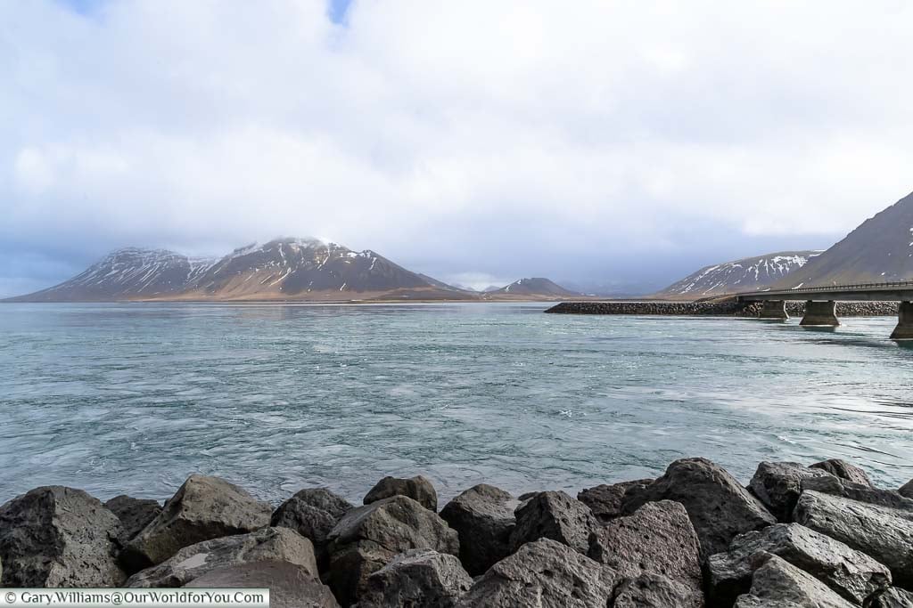 The view over the fast-flowing waters of Kolgrafafjödur fjord, in northwest Iceland, next to Route 54, with the mountains in the background