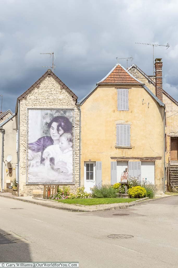 An enlarged picture of Gabrielle and Jean by Pierre-Auguste Renoir on the side of a building in Essoyes, in the champagne region of france