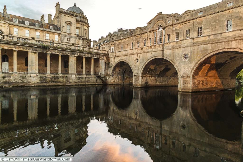 Pulteney Bridge in Bath at dusk from the east bank of the River Avon