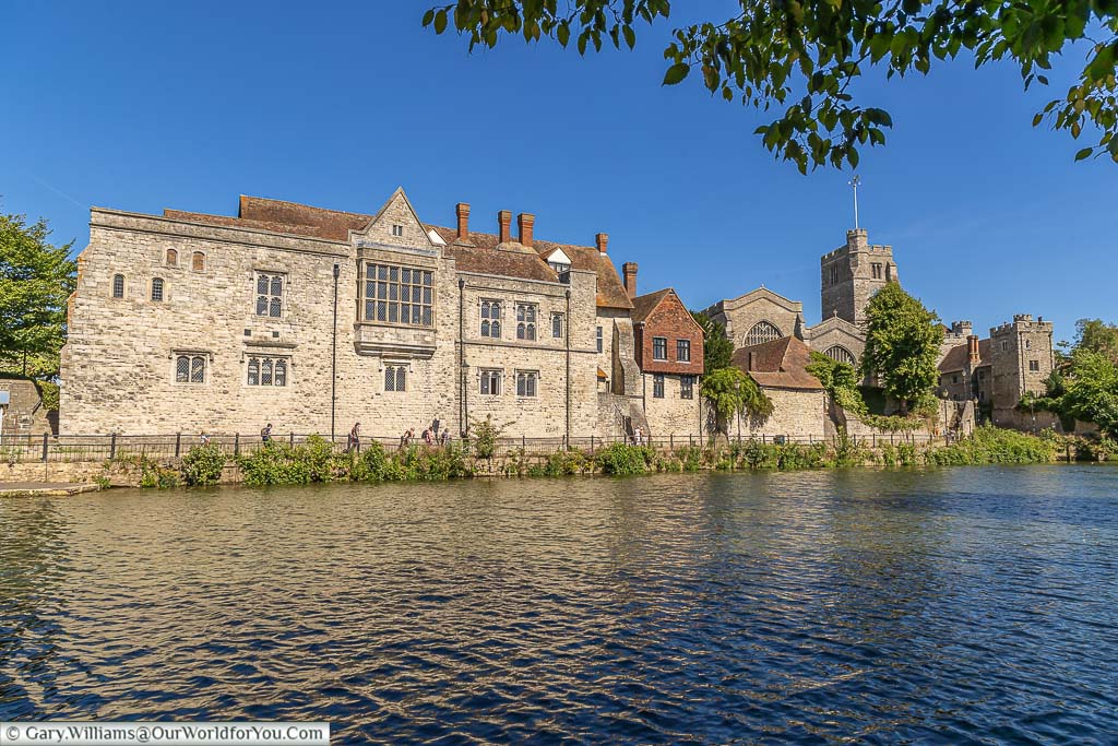 The Archbishop's Palace in Maidstone from the opposite bank of the river medway on a clear day under blue skies.