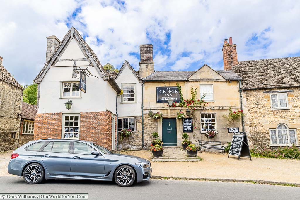 A car parked outside the historic George Inn in the National Trust village of Lacock in Wiltshire.
