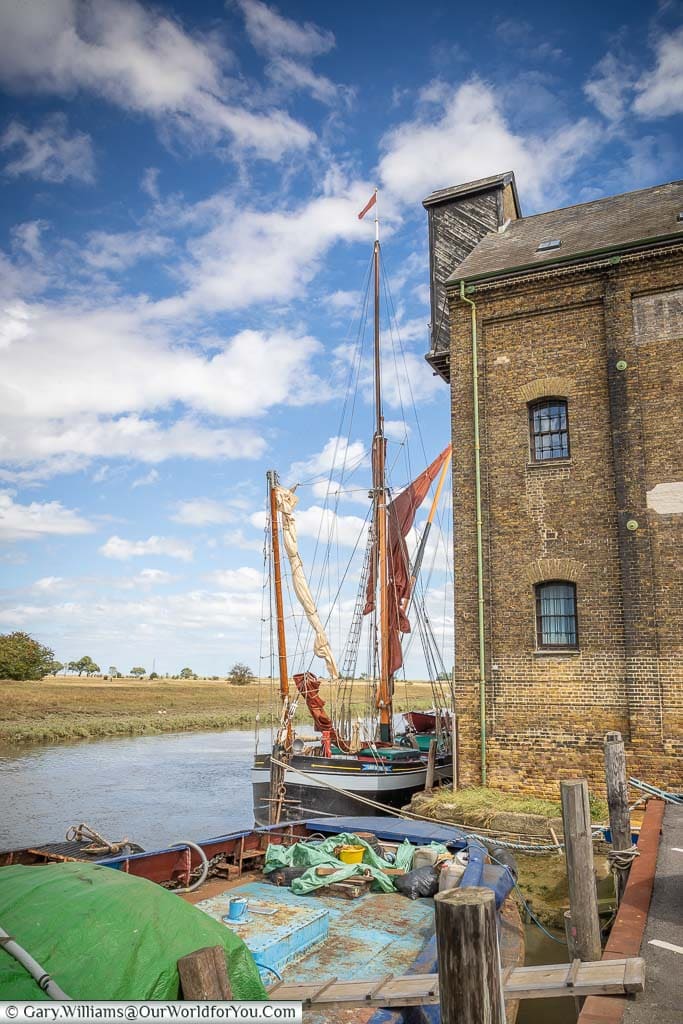 An old sailing barge moored next to the Oyster Bay House on Standard Quay in Faversham, Kent