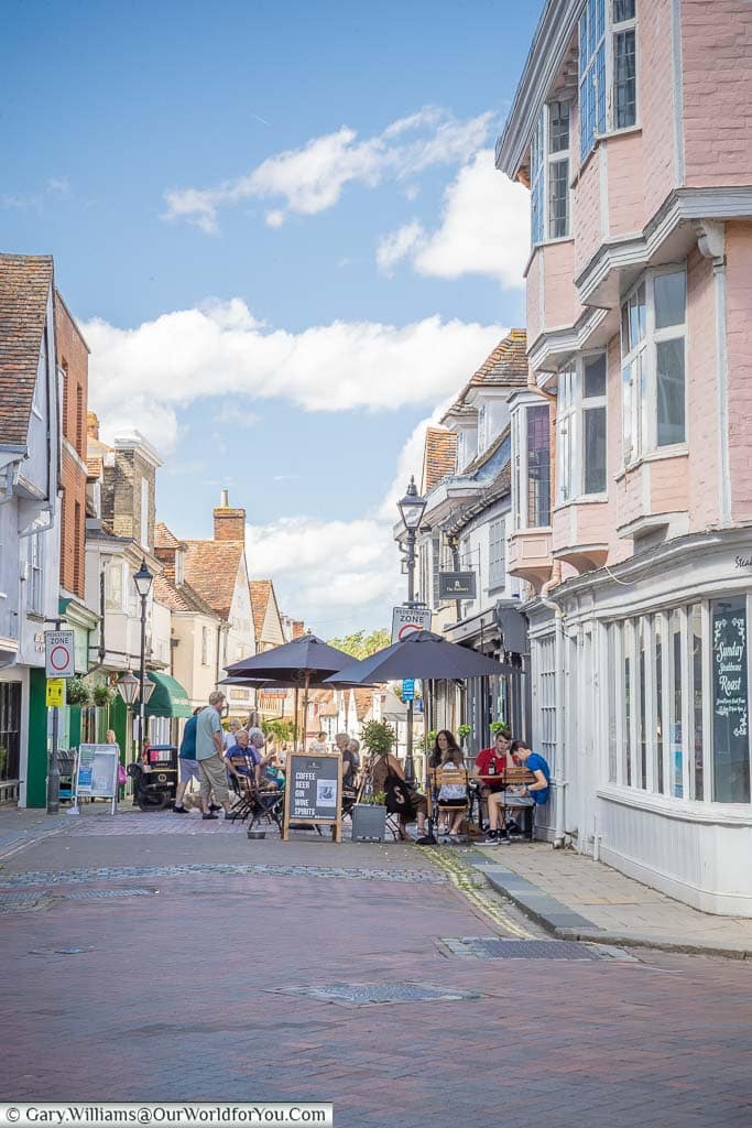 Diners sitting outside restaurants at the top of West Street in the charming town of Faversham in Kent.