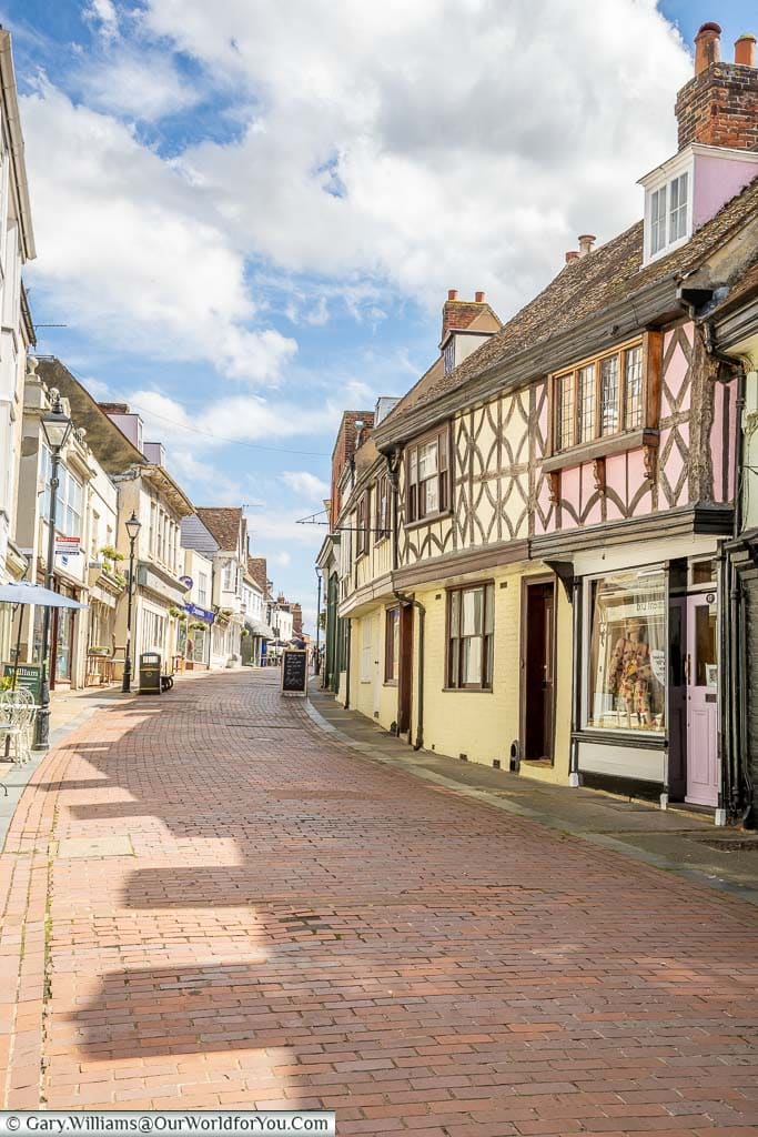 The view up the pedestrianised West Street in Faversham, towards Market Square, lined on either side by Tudor half-timbered buildings. A historic market town in Kent.