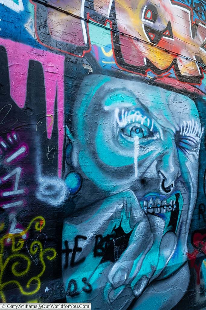 A close section of Graffiti Street in Ghent featuring a haunted face.