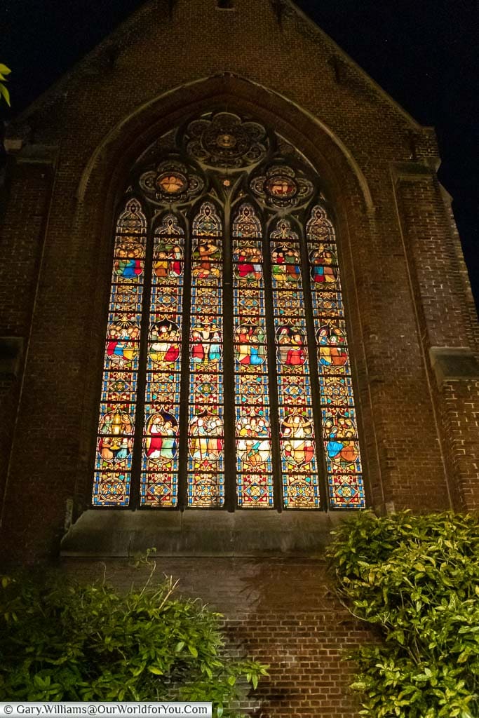 The stained glass window at the Monasterium Poortackere in Ghent at night.