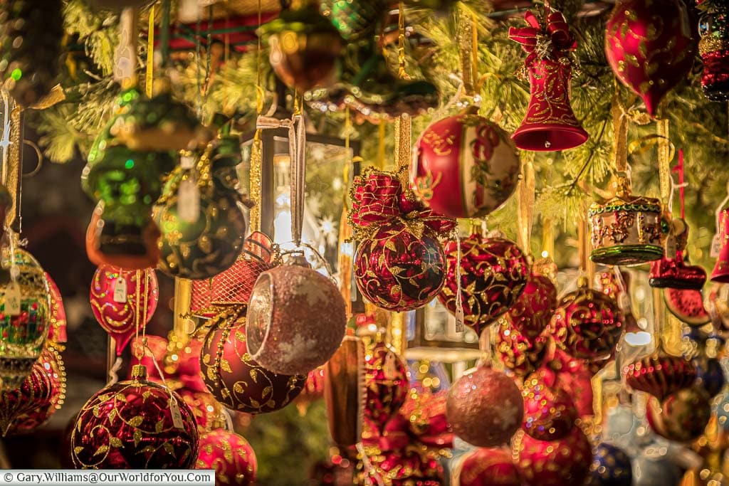 A close-up of a selection of traditional, predominately red, baubles for sale.