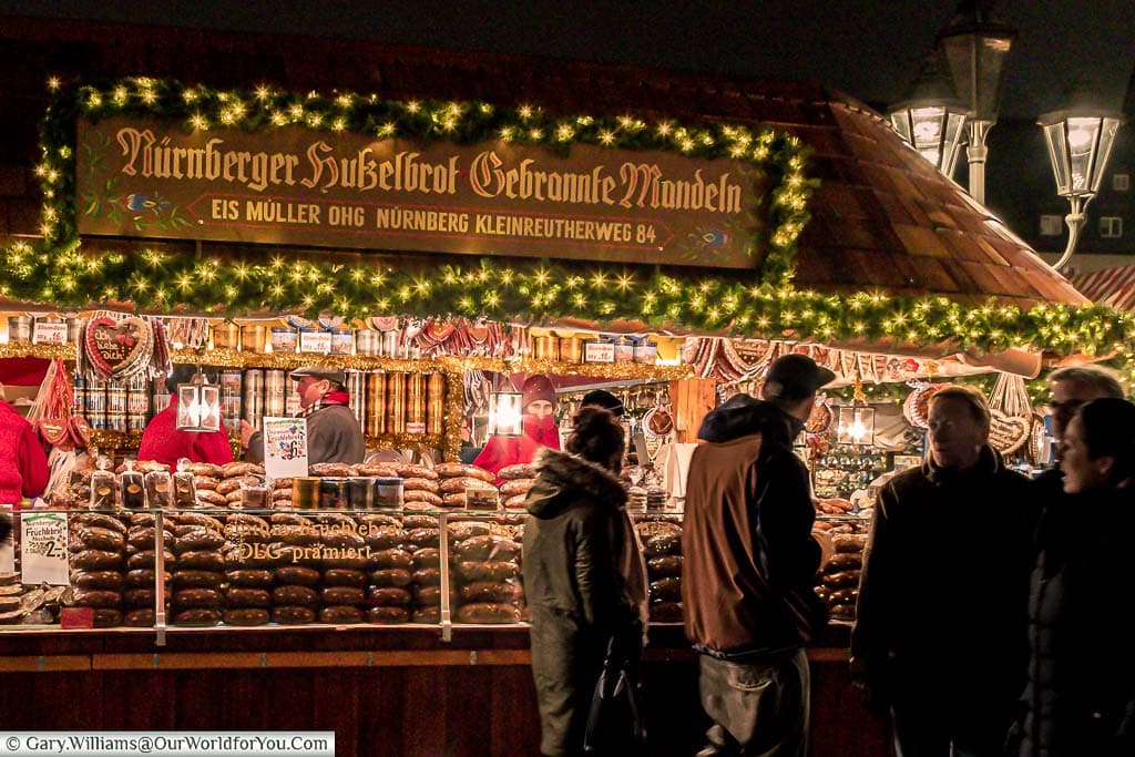 A stall stacked high with the Nuremberg gingerbread loaves as folks pass by.