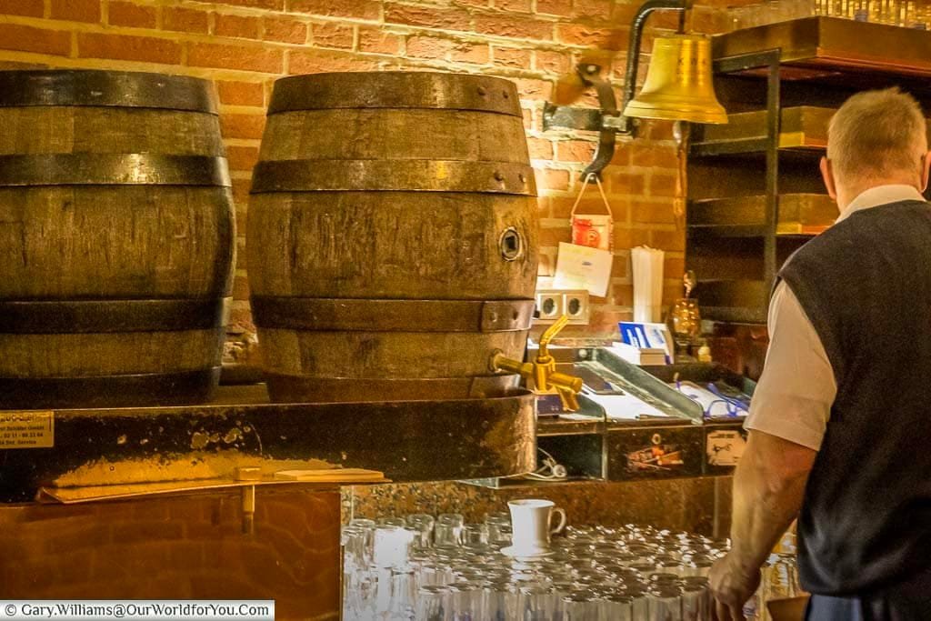 Two wooden barrels, with their iron rings, one with a brass tap on a counter in a traditional bar in düsseldorf, germany at christmas.