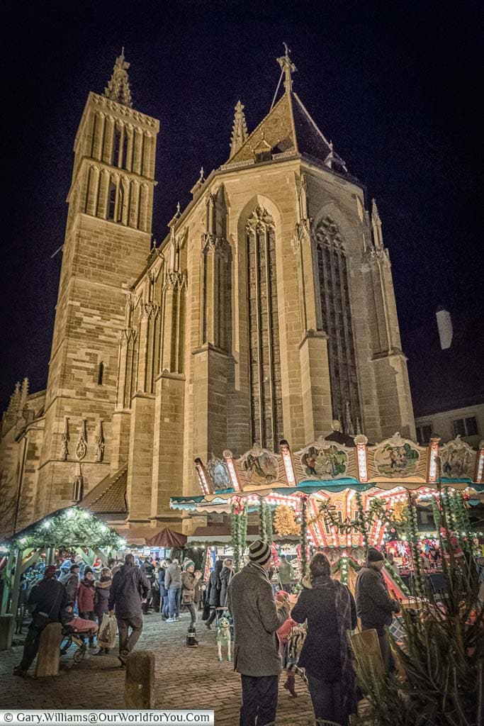 The nave end of St Jakobs church and a carousel in the christmas markets at rothenburg ob der tauber at night