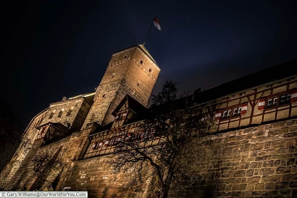 Looking up at nuremburg's castle walls at night during the wintery german chistmas market season