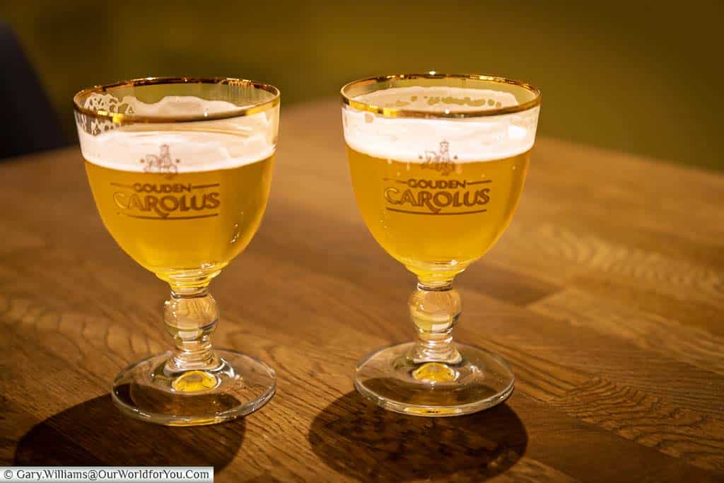 Two glasses of the golden yellow gouden carolus tripel from the het anker brewery in mechelen, belgium