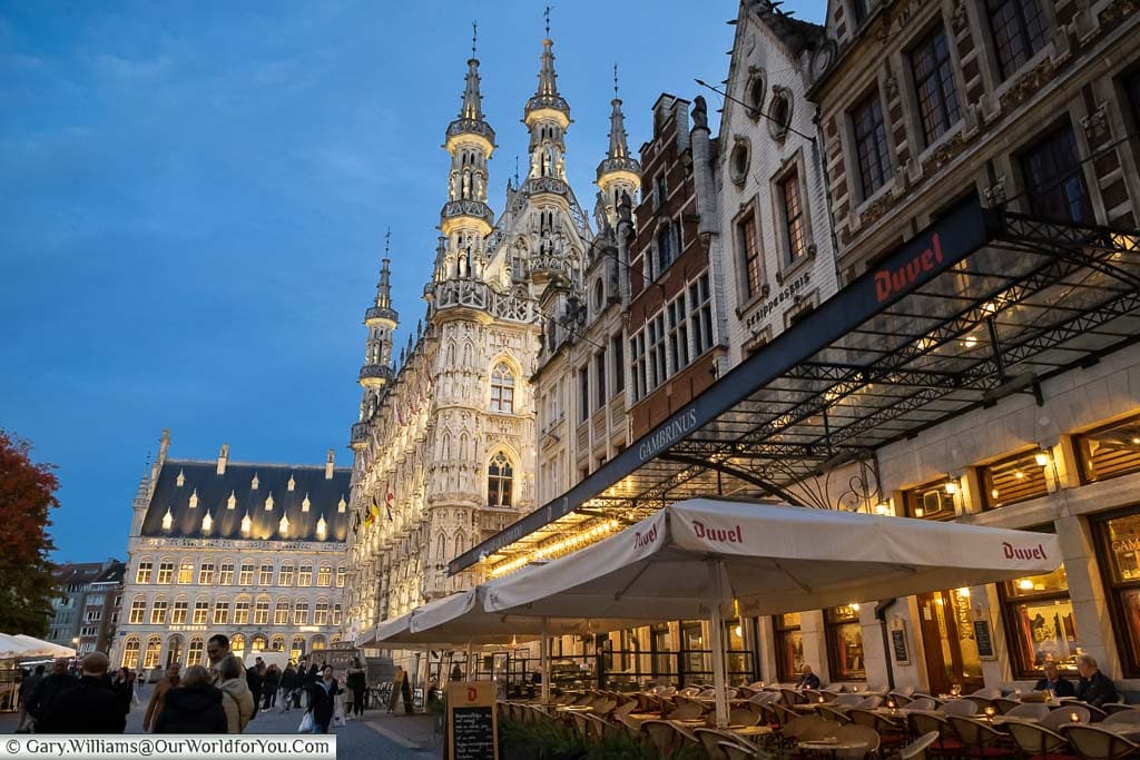 The Grote Markt in Leuven from outside a cafe at dusk with the ornate town hall and number four in the distance.