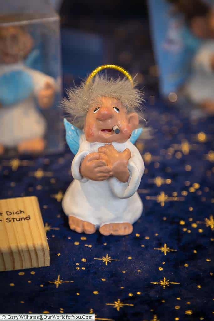 A hanging christmas tree decoration from nuremberg of an angel smoking a cigarette