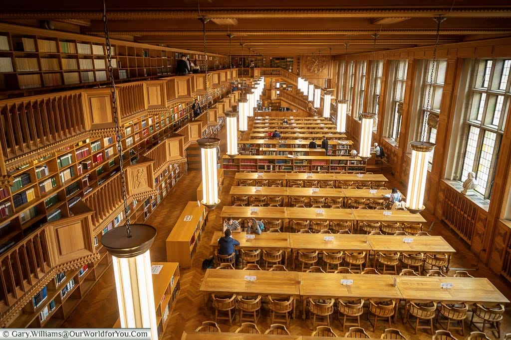 Looking down from the first floor across the wooden interior of the historic University library in Leuven