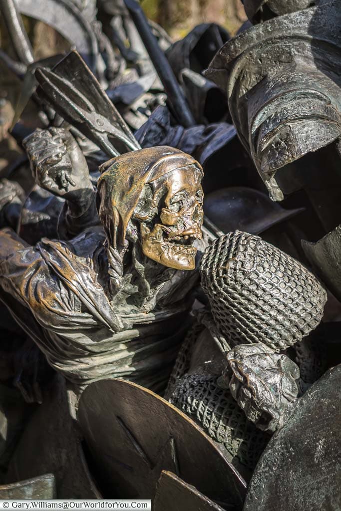 A close-up of dusseldorf's city founding monument, focusing on the bronze skull of a figure fighting in a medieval battle.