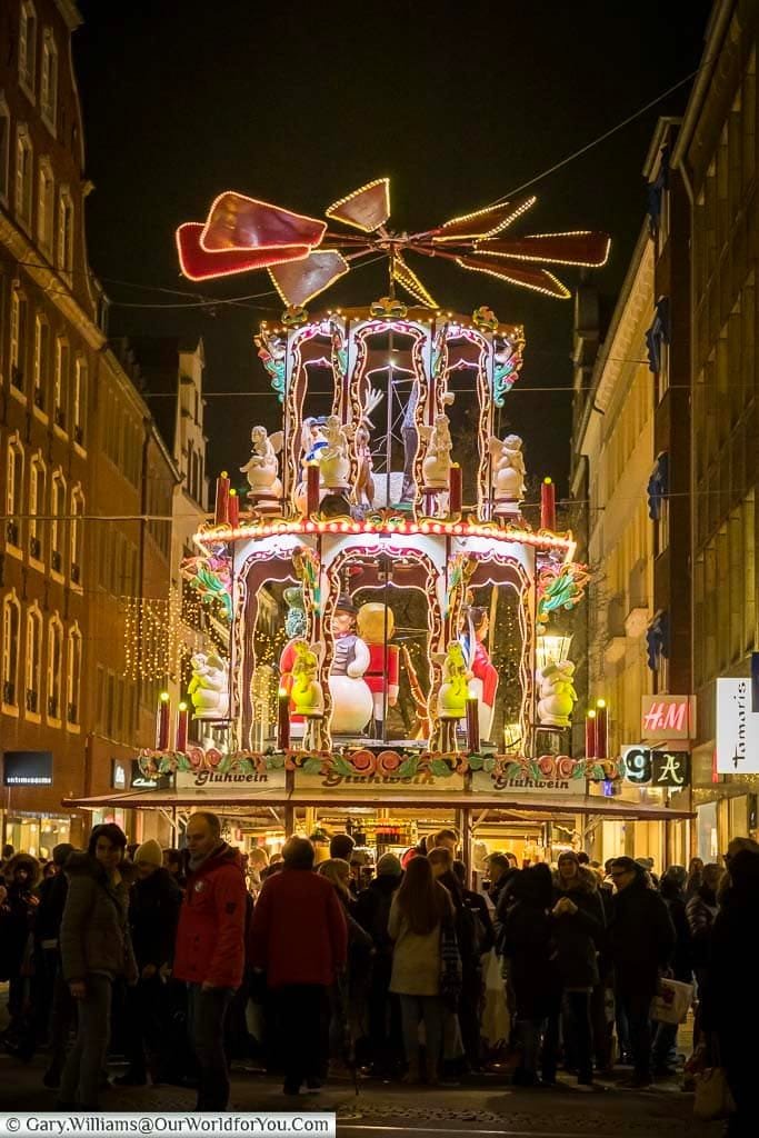 Crowds gather around the drink stall at the base of the three-storey illuminated christmas pyramid on Flinger Strasse in düsseldorf at night