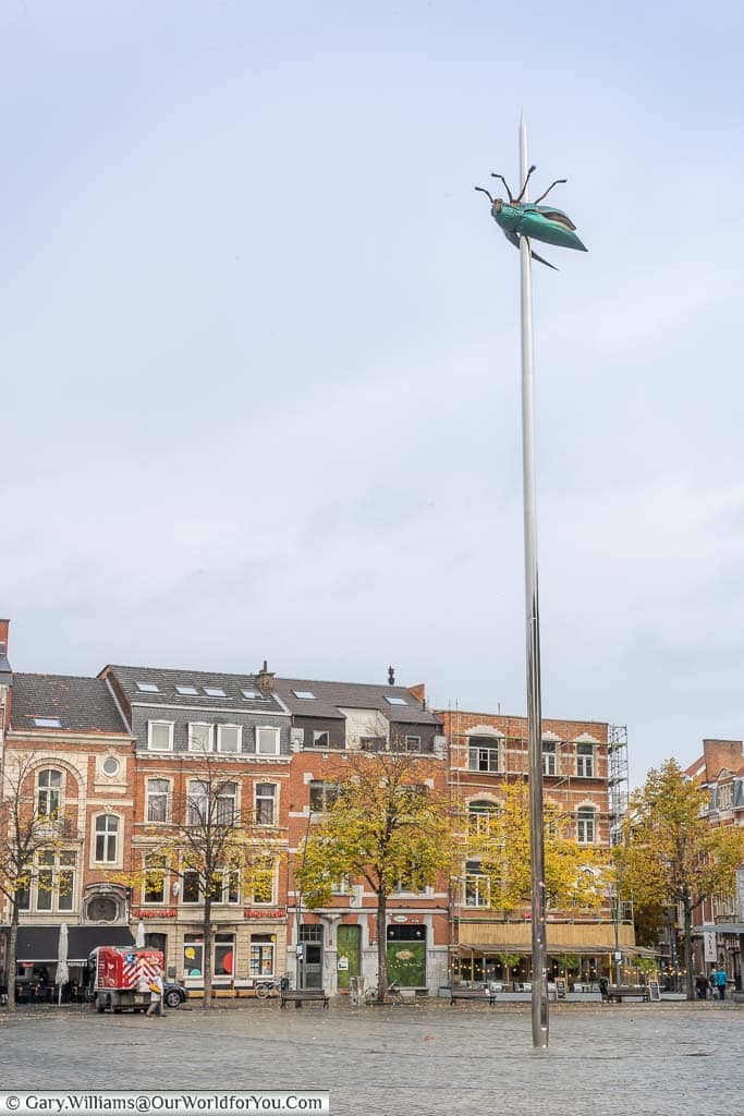 Totem, a green beetle speared on a giant needle in the Monseigneur Ladeuzeplein square in Leuven, Belgium