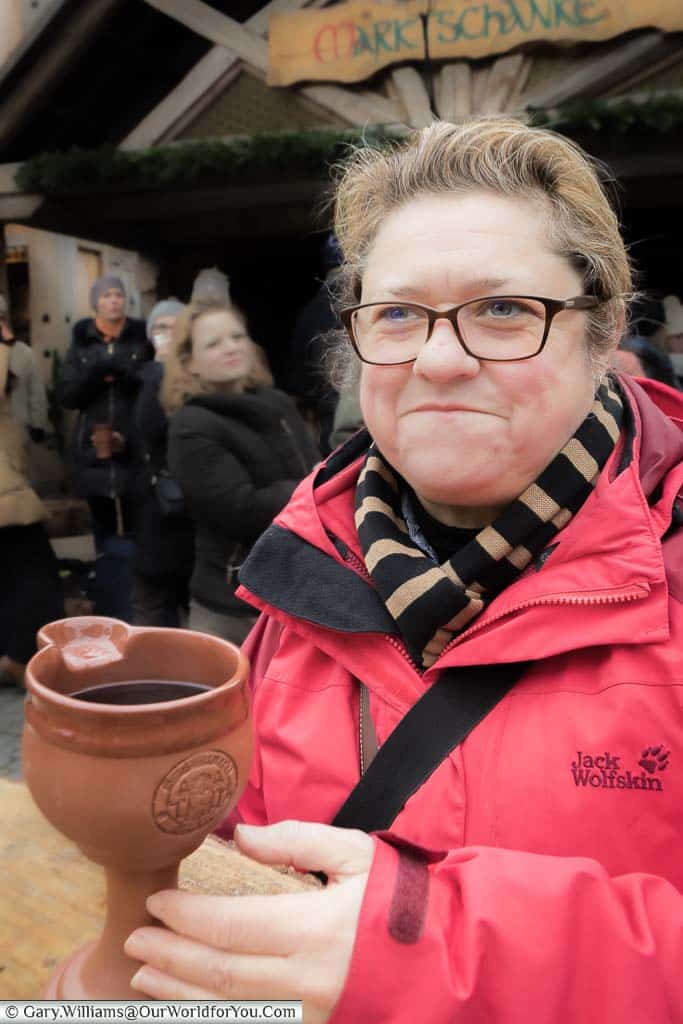 Janis wrapped up warmly with her bright red Jack Wolfskin jacket, and strippy scarf, reaching out to her terracotta goblet containing her gluhwein.
