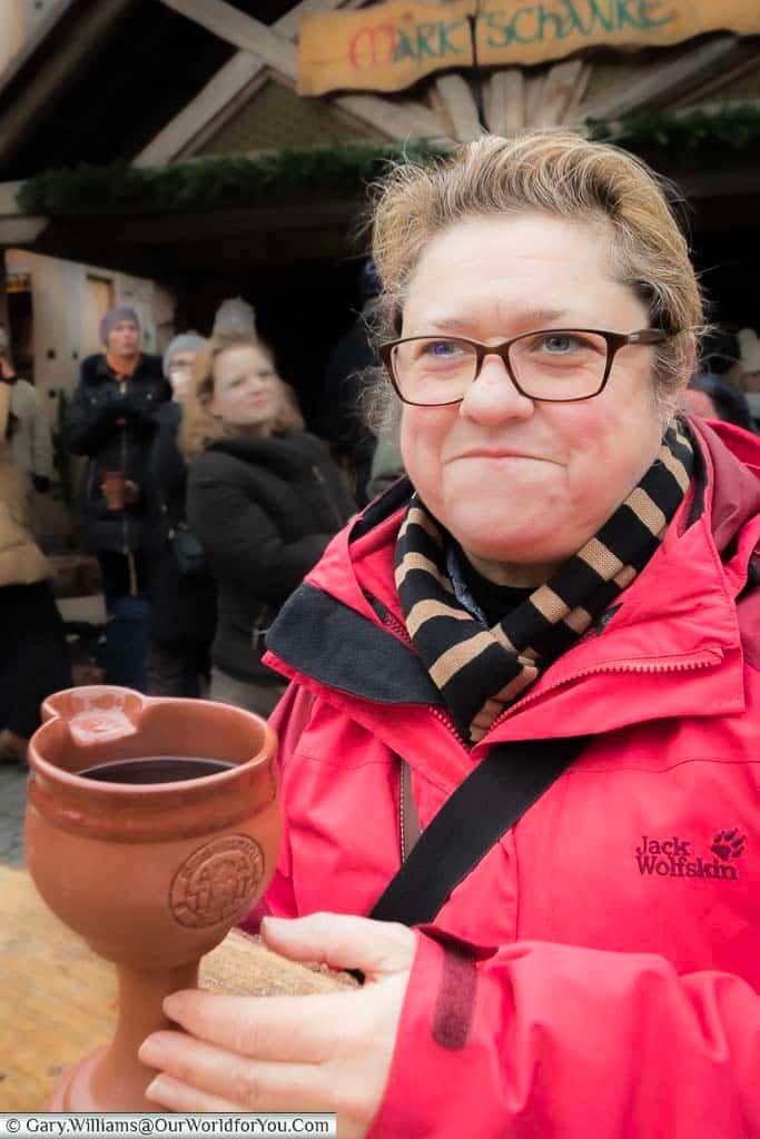 Janis wrapped up warmly with her bright red Jack Wolfskin jacket, and strippy scarf, reaching out to her terracotta goblet containing her gluhwein.