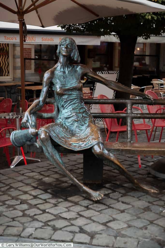 The ‘De Kotmadam’ sculpture of a Leuven landlady sitting on a bench in Oude Markt