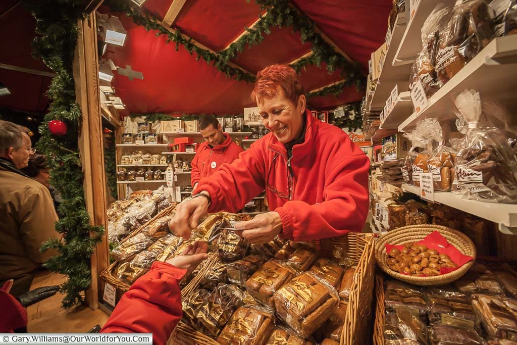 The Aachener Printen gingerbread stall in Cologne. It's stacked his with all the different styles of gingerbread biscuits. The lady behind the counter is handing Janis back her change after we've bought another bag load.