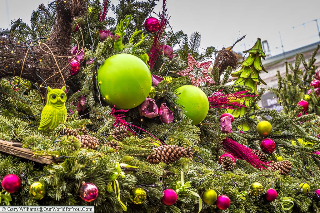 A christmas market stall in stuttgart, germany, decorated with dayglo green and magenta elements.