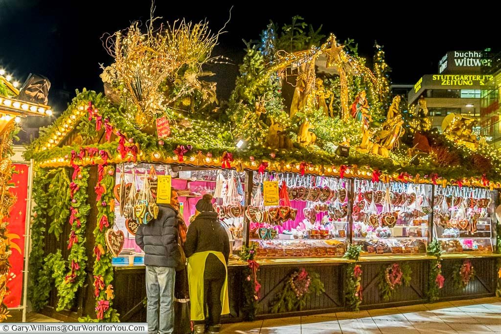 A festive nativity display glistening above a gingerbread stall in Stuttgart's Christmas Market