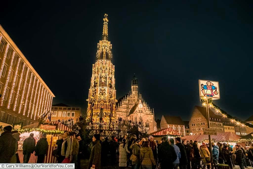 People gathering in front of the Schöner Brunnen at the edge of Nuremberg’s historic Christkindlesmarkt