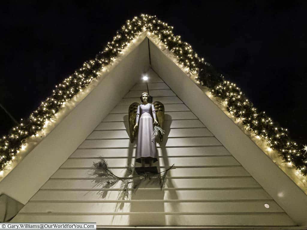 An angel on a white weatherboarded gable end of a christmas market stall in cologne's market of angels