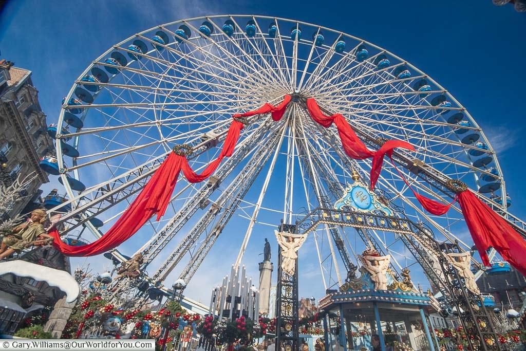 The giant white Ferris wheel decorated with a red ribbon in Lille at Christmas