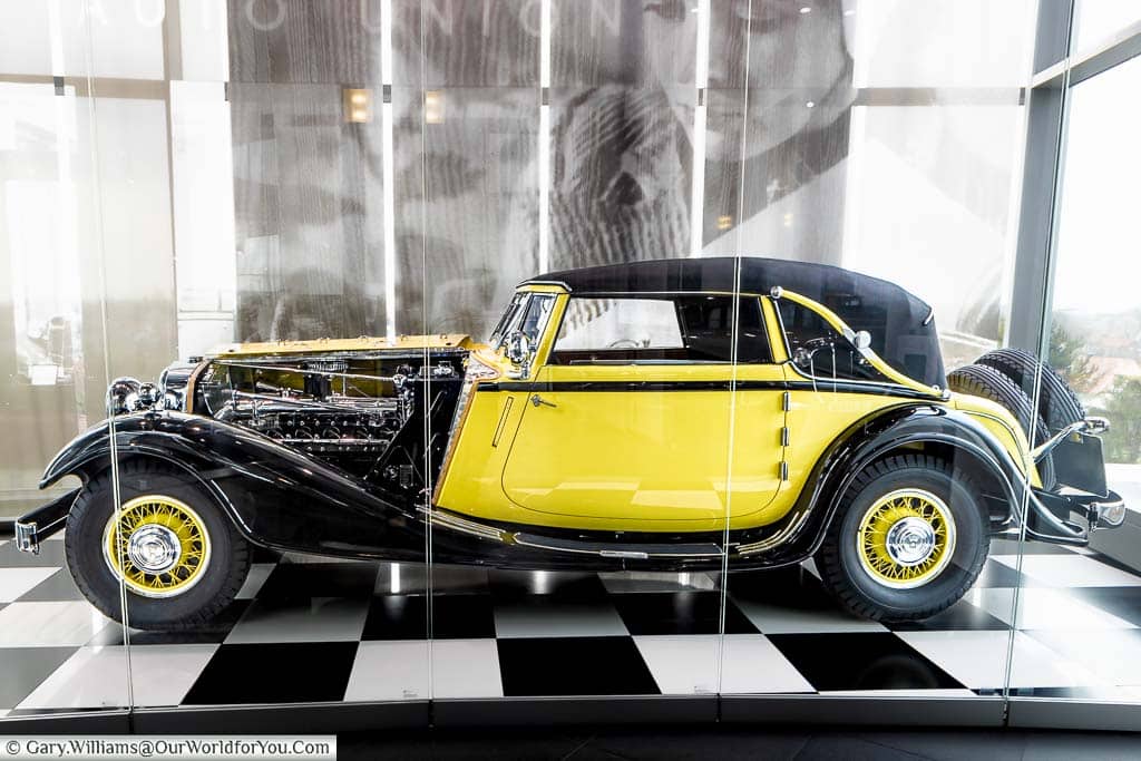 A classic Horsh 12 Type 670 Sports convertible from 1931 in a beautiful, vibrant sunflower yellow and black contrasting paint scheme in a glass display box at the audi forum ingolstadt