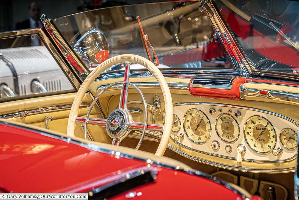 A close-up of the cream coloured dashboard of the red mercedes 500 K special roadster on display in the mercedes benz museum in stuttgart