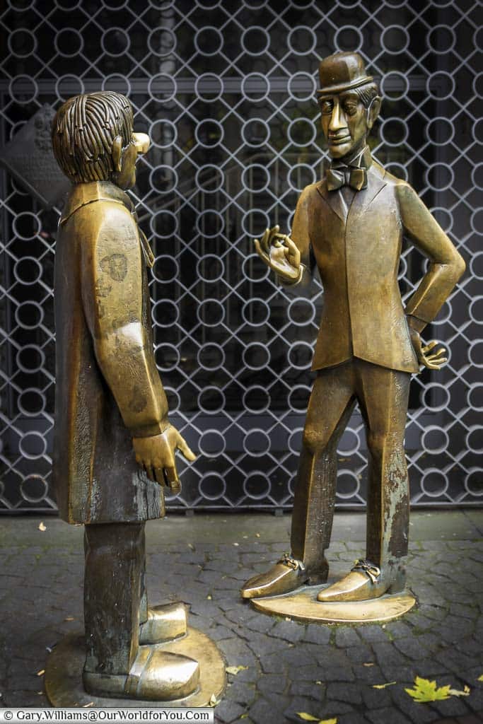 Two life-size brass statues of characters that represent the soul and character of the city of Cologne.