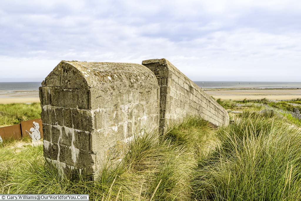 The edge of Cosy's Pillbox, on Juno Beach, Normandy with a view out to the sea on an overcast day.