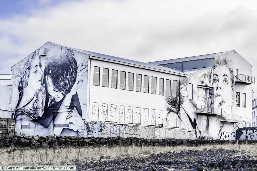 A disused building in Reykjavik, Iceland, that has been used as a canvas for two portraits of couples close embrace.