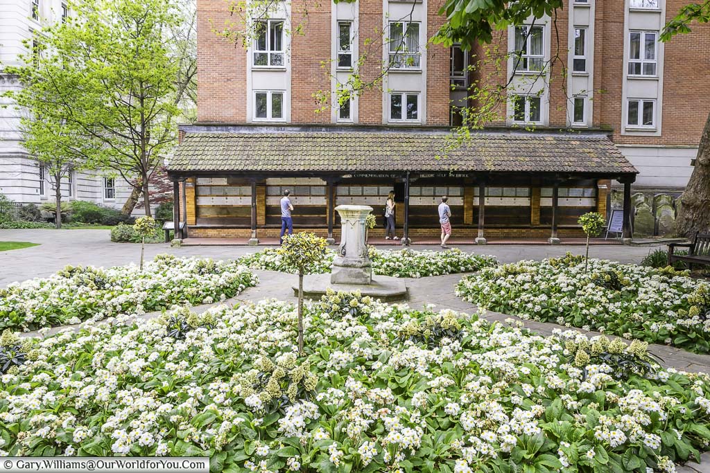 The flower beds iÉn Postman's park in the City of London in front of the memorial for heroic sacrifice.