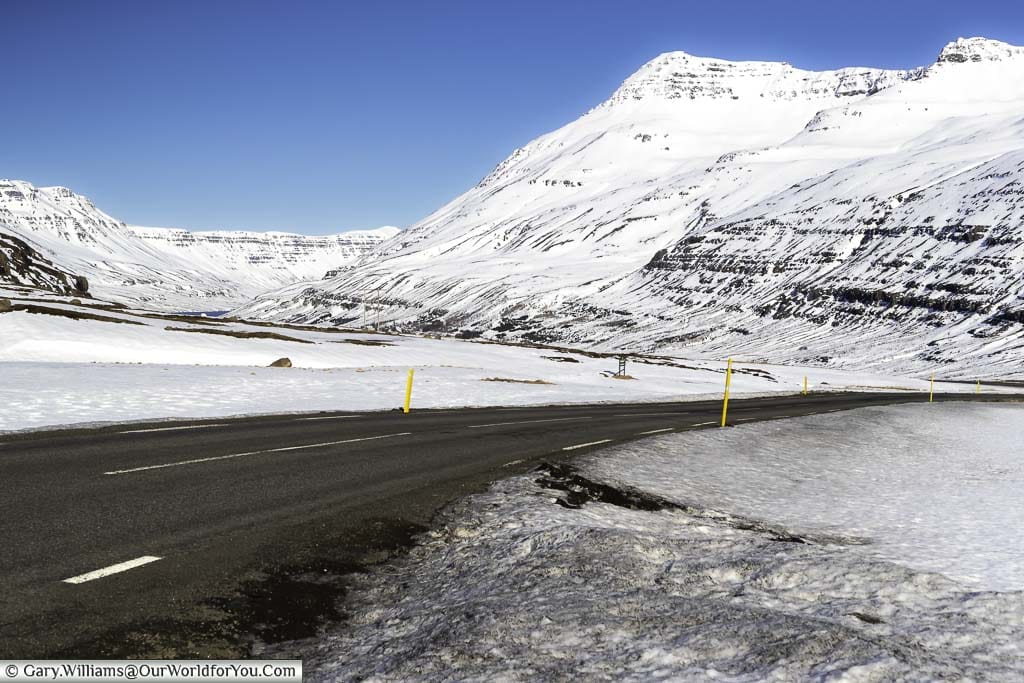 Route 93 weaving its way between snow-capped mountains in Eastern Iceland