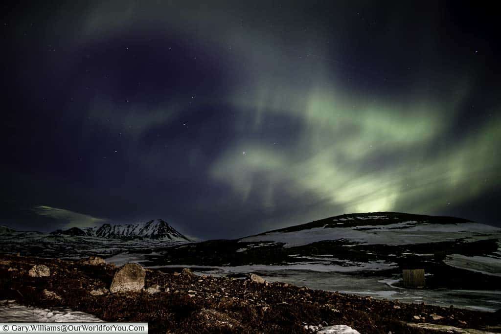 The swirling green colours of the Northern Lights over the mountains just outside Reykjahlíð in Eastern Iceland