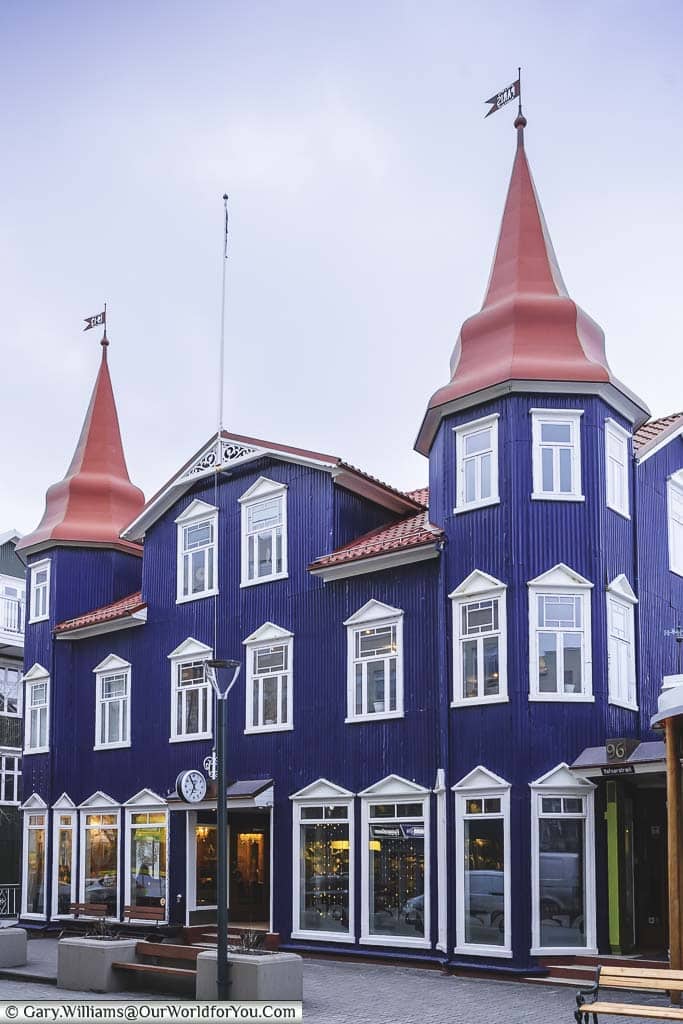 The Blue Cafe, a charming Victorian-looking blue building with a red roof and two red turrets in Akureyri, Iceland