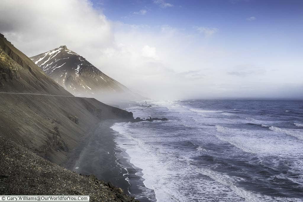 Waves crashing against the coastline of eastern Iceland alongside route one on a bright day