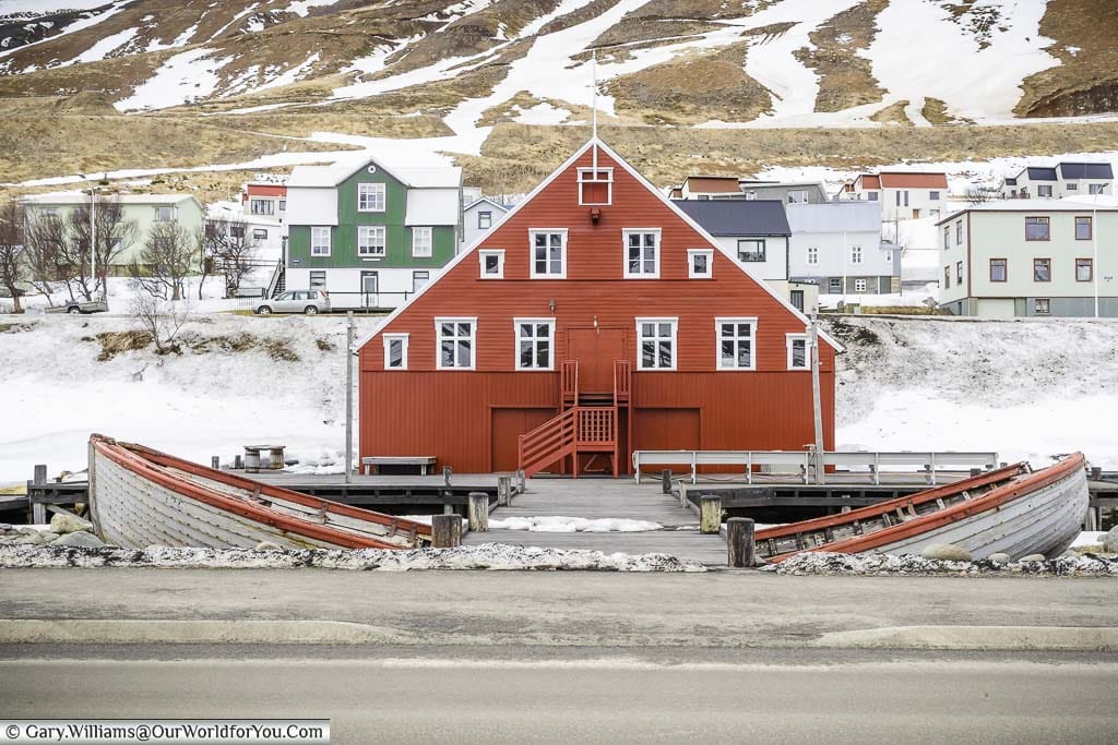 Two halves of a herring boat flank the path to the russet red herring museum in Siglufjörður, Northern Iceland.