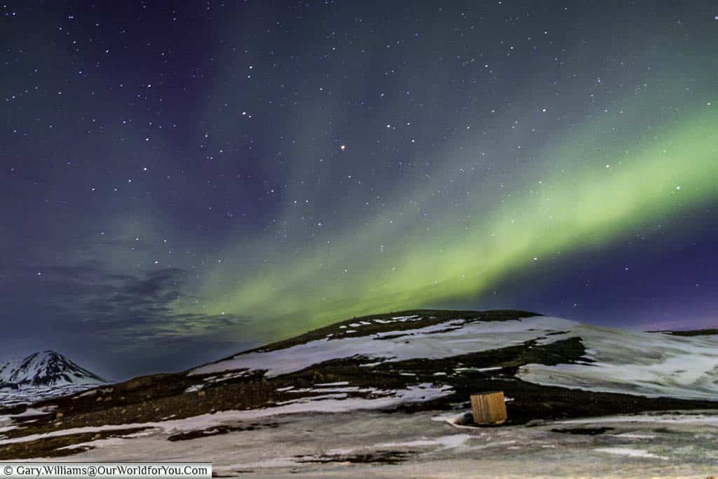 The Northern lights in full display on a star-filled night over the landscape of Reykjahlíð in Iceland