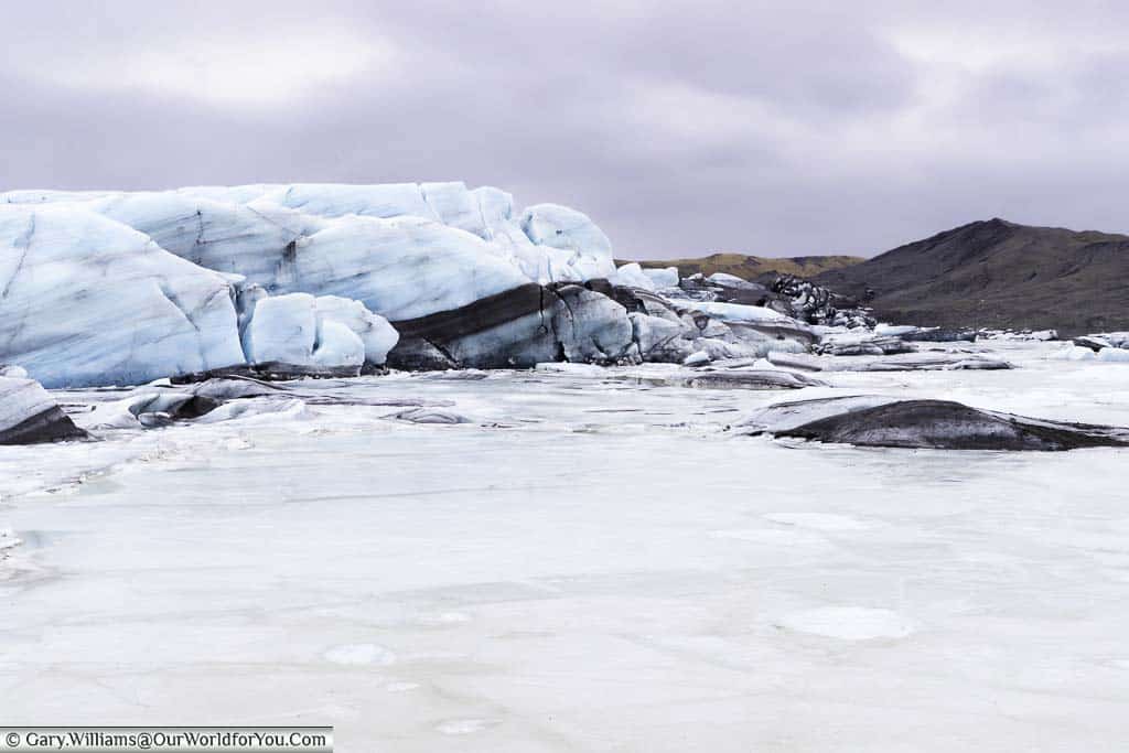 The edge of the pale blue Skaftafellsjökull glacier where it meets a frozen cloak