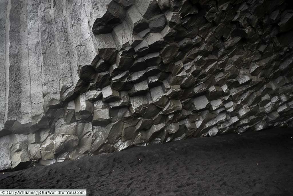 The hexagonal structure of the Basalt rock pillars at the entrance to a cave on Reynisfjara Beach