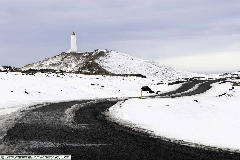 A gravel road in iceland leading to the Reykjanes Lighthouse atop a hill