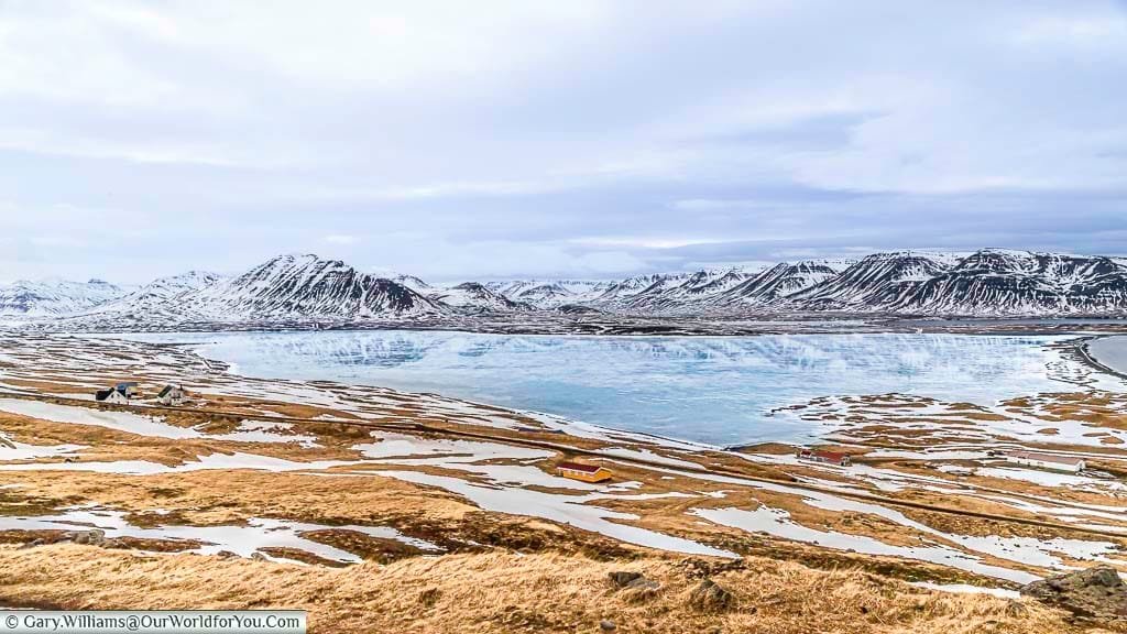 A mirrored view of a mountain range in the frozen Miklavatn lake in Northern Iceland