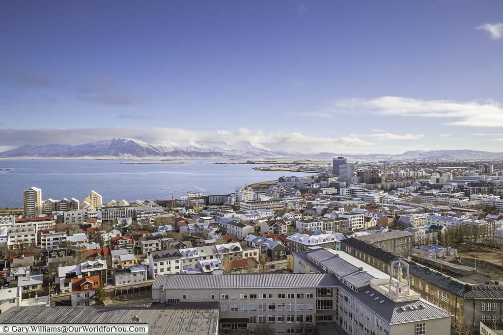 A view from the top of reykjavik's iconic Hallgrímskirkja church with a view off to the north of iceland's capital to the mountains beyond.