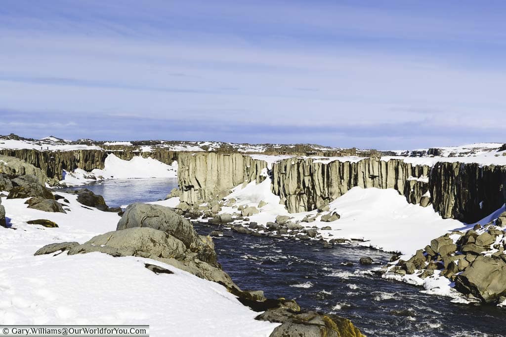A white water river flows along a basalt gorge on the journey between the Selfoss and Dettifoss waterfalls in Iceland.